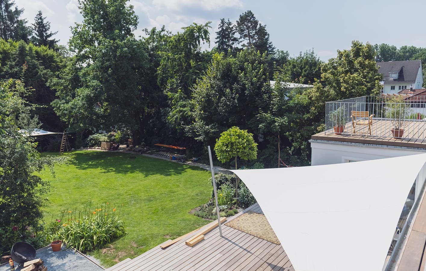 Moderne Sonnensegel in für den Außenbereich Blick von oben in einen Garten und auf Terrasse - geschützt durch ein Sonnensegel